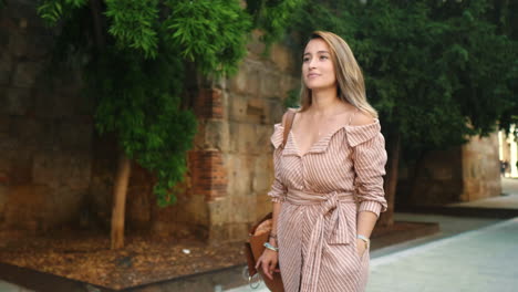 happy woman walking near stone wall