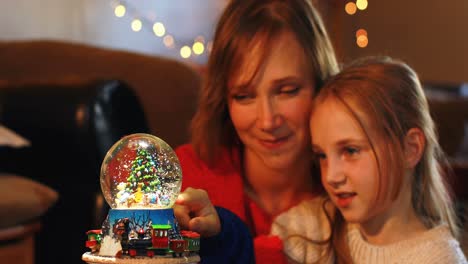 Mother-and-daughter-playing-with-crystal-ball-toy-during-Christmas-4k