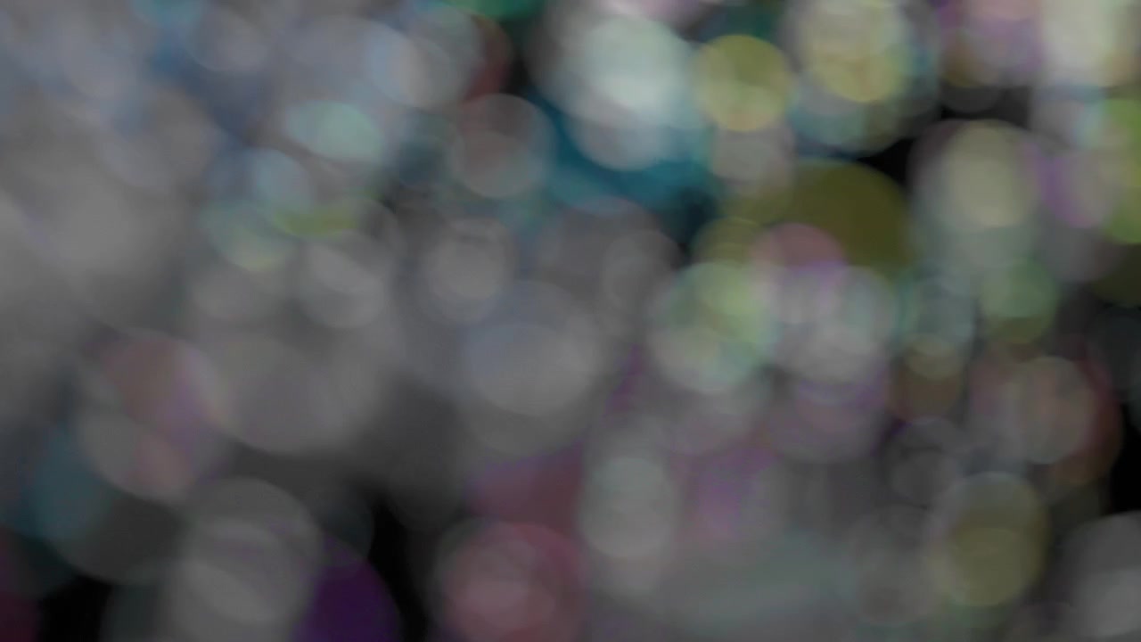 Sfondo bokeh astratto di bolle di sapone colorate volanti. Movimento lento.