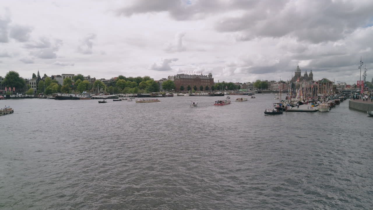 Boat ship sailing festival parade in the Netherlands, Amsterdam, wide angle view of the city town centre with sailing ships ferries and boats in European authentic style