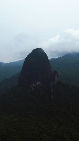 vertical drone shot circling the joão dias pai and filho peaks, on principe island