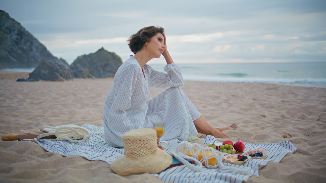 외로운 소녀가 바위 바다 해안에서 휴식을 취하고 있습니다. 아름다운 여성이 피크닉을 즐기고 있습니다.