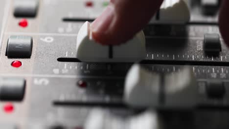 Mixing-Console,-Finger-On-Channel-Fader-Gradually-Increasing-And-Decreasing-Level-Of-An-Audio-Signal