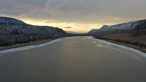 Impresionante-Puesta-De-Sol-Se-Refleja-En-El-Río-Thompson-Cubierto-De-Nieve