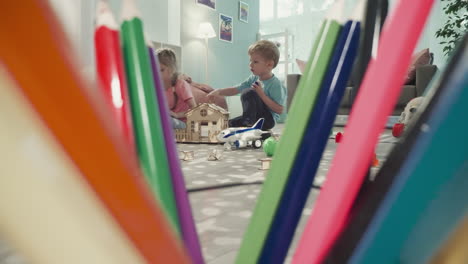 Siblings-decorate-roof-of-house-with-colorful-plastic-blocks