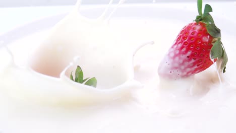 fresas que caen en la leche