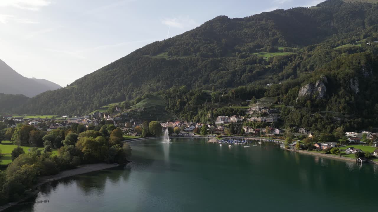 drone vuela hacia adelante sobre la ciudad de weesen con sede cerca de la orilla del lago walensee, suiza