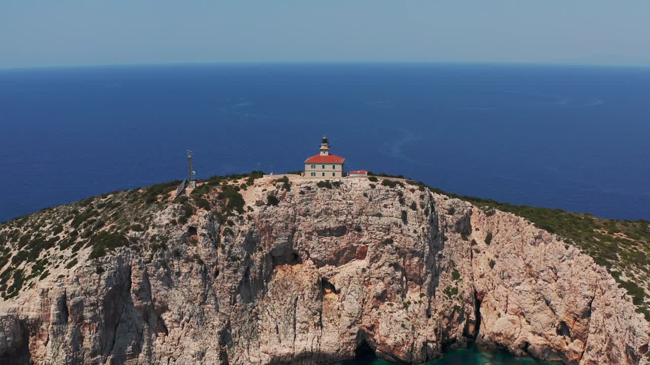 Susac Lighthouse Atop Limestone Cliffs Near Lastovo, Croatian Island. Aerial Pullback Shot