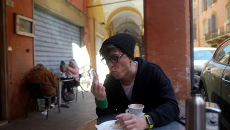person eating and drinking coffee in a european city cafe