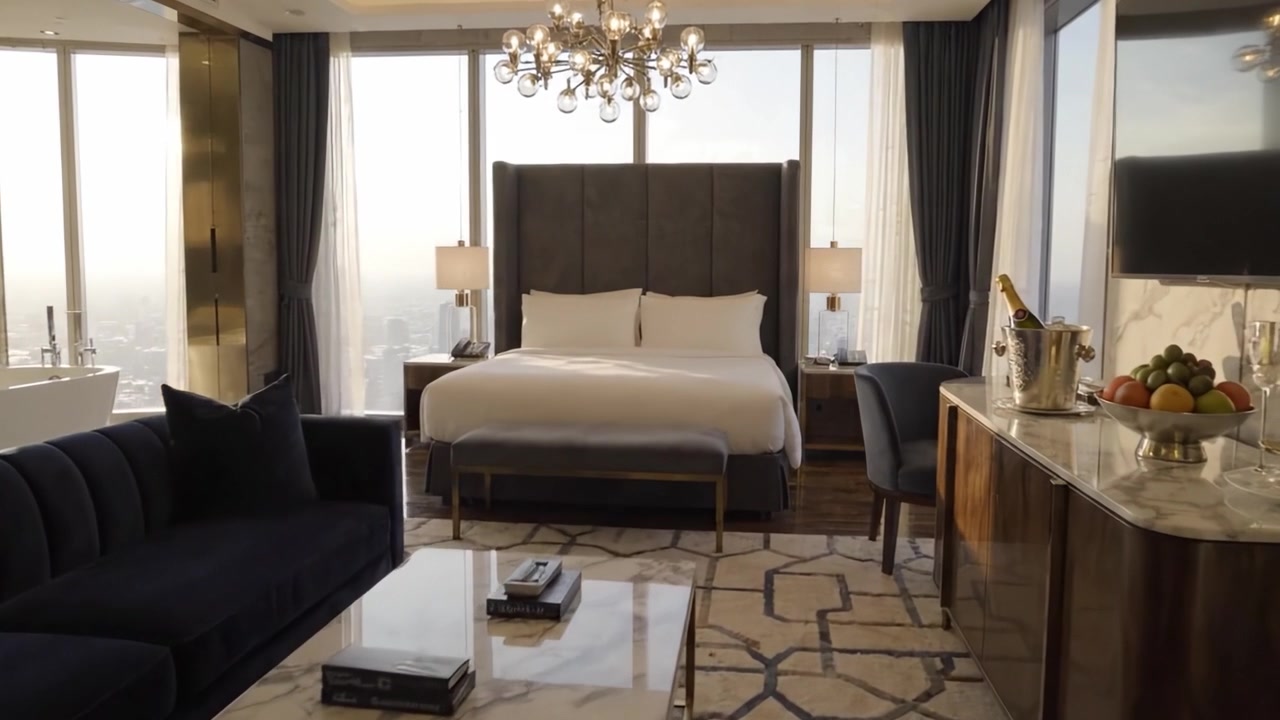 Interni di suite d'hotel di lusso con design moderno, viste mozzafiato, accogliente area salotto e arredi eleganti, perfetta per relax e comfort.