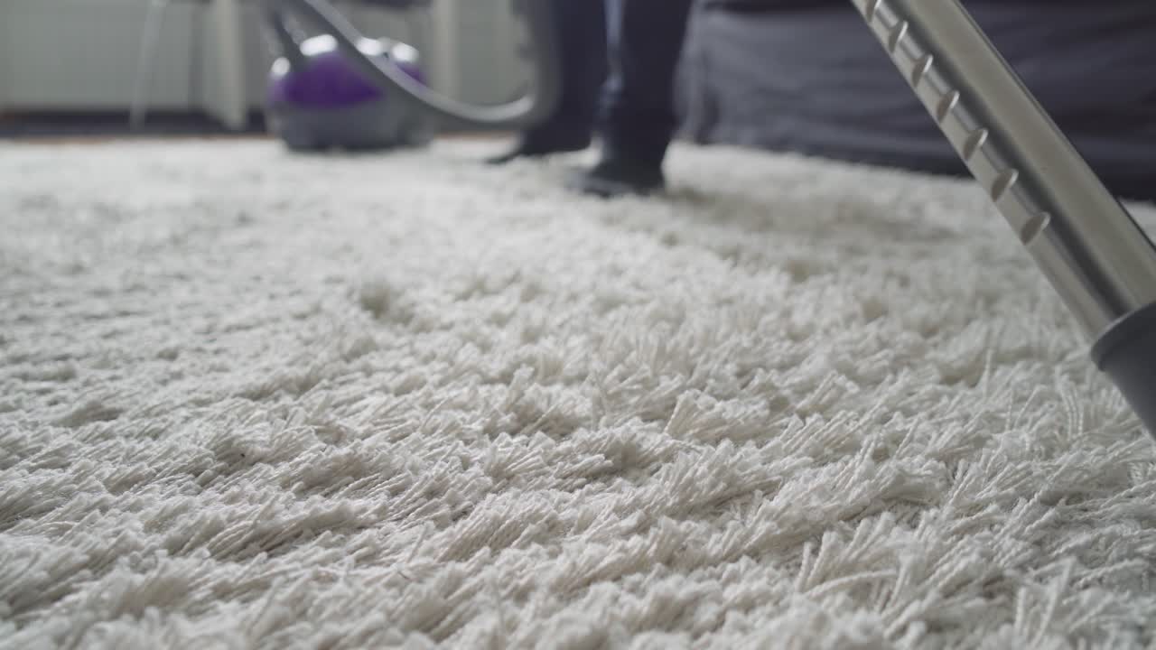 hombre usando una aspiradora y ajustando el cabezal de succión