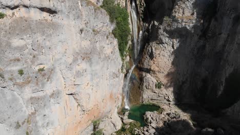 Tiro-Inclinado-Hacia-Abajo-De-La-Cascada-Salto-De-Los-Órganos,-Mientras-El-Agua-Limpia-Cortaba-Las-Rocas-Formando-Un-Estanque-En-El-Fondo-De-Los-Acantilados