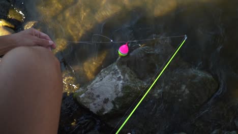 Pescador-Instalando-Equipo-De-Flotación-De-Caña-En-La-Línea-De-Pesca,-Listo-Para-Lanzar