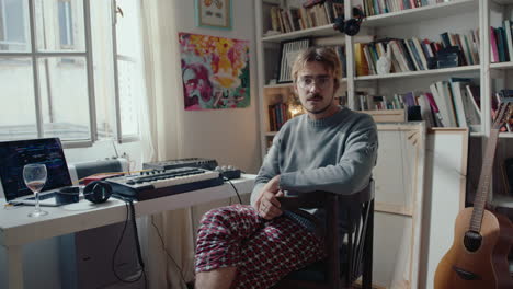 young man posing for camera at home music studio