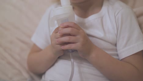 girl with bronchitis undergoes procedure with inhaler in bed