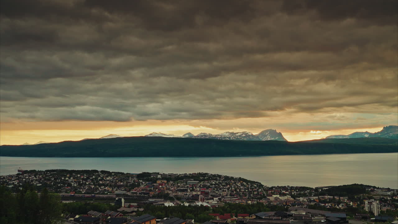 Time lapse of the midnight sunset over the Norwegian fjords in Narvik.
View of the dramatic traveling clouds at golden hour. Picturesque nordic landscape.