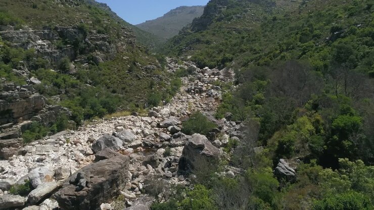 Volo a bassa quota attraverso il fondo di una gola fluviale aspra e rocciosa.
