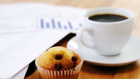 Coffee-cup-with-graph-document-and-cupcake