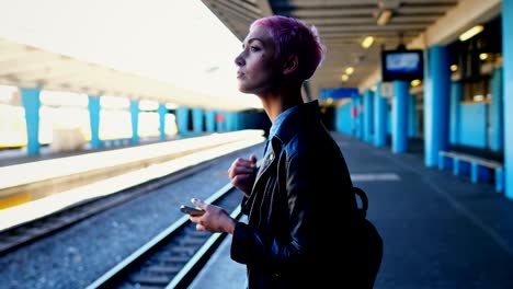 woman using mobile phone while waiting for train 4k