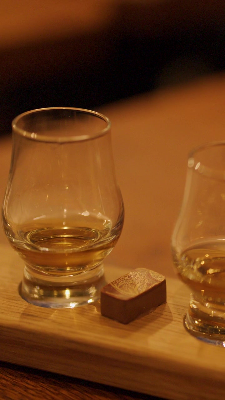 Degustazione di whisky con cioccolatini gourmet su un tagliere di legno