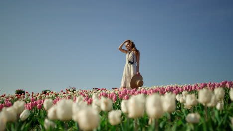 Camera-tracking-around-young-woman-with-camera-enjoying-sunny-day-in-tulip-field