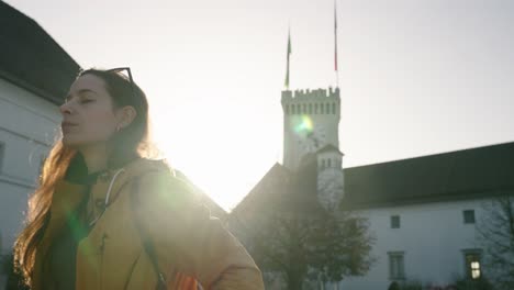 tourist woman take off sunglasses and observes square of ljubljana castle, slovenia