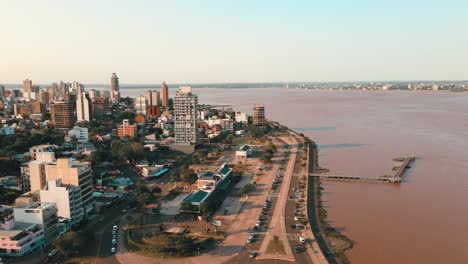 Dron-Acercándose-A-La-Avenida-Costanera-En-Posadas,-Misiones,-Argentina,-Revelando-El-Pintoresco-Paseo-Marítimo-Y-El-Paisaje-Urbano