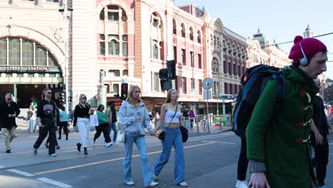 people crossing street near historic train station