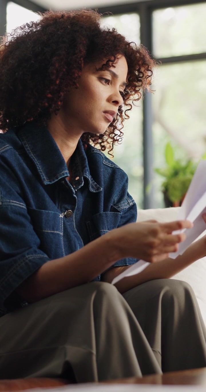 Young Woman Reviewing Documents and Feeling Stressed at Home