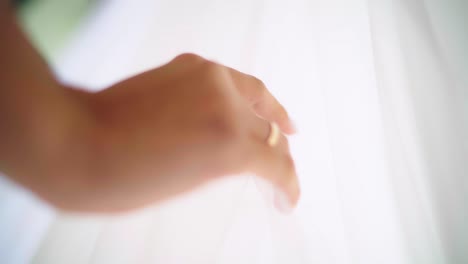 Woman's-hand-slipping-gently-down-the-veil