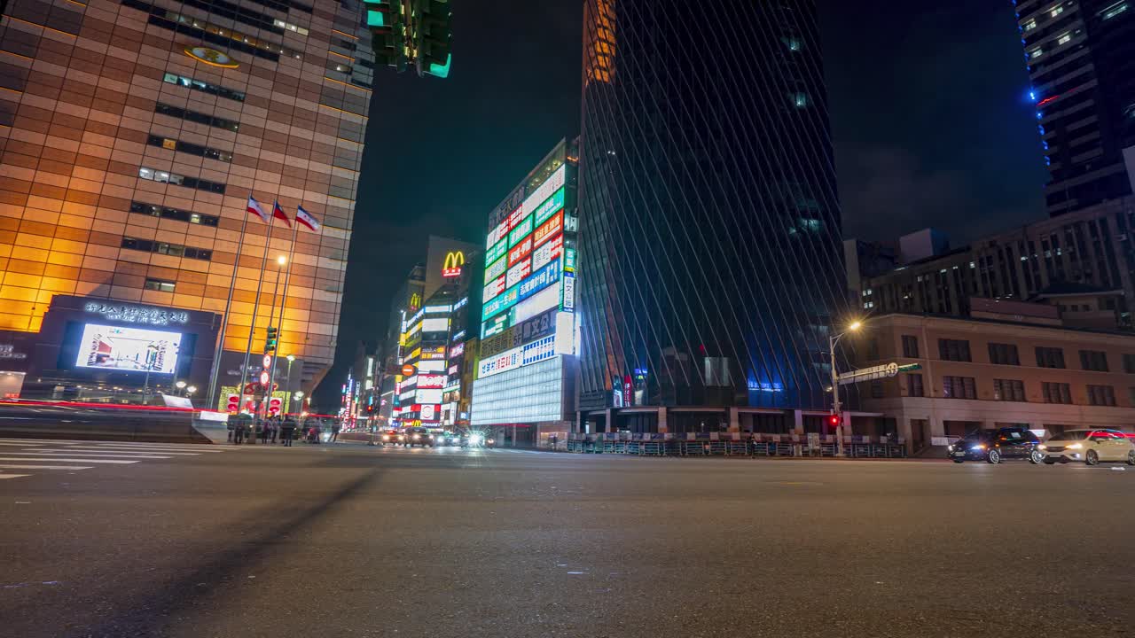 Panning View of Night City Time Lapse From Left to Right at Zhongxiao West Road Busy Intersection with Traffic and Pedestrians in Metropolitan Taipei Taiwan.