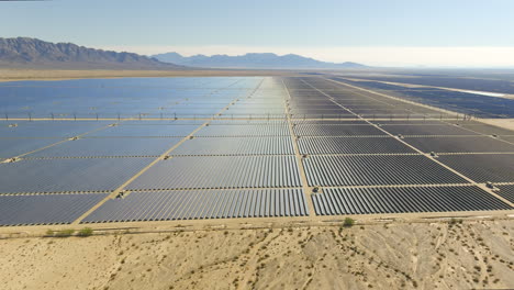 aerial push in shot over a vast solar power farm in the desert of california usa