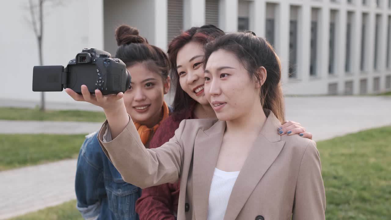 Asian female friends bloggers creating content for social media while making a video with a camera.