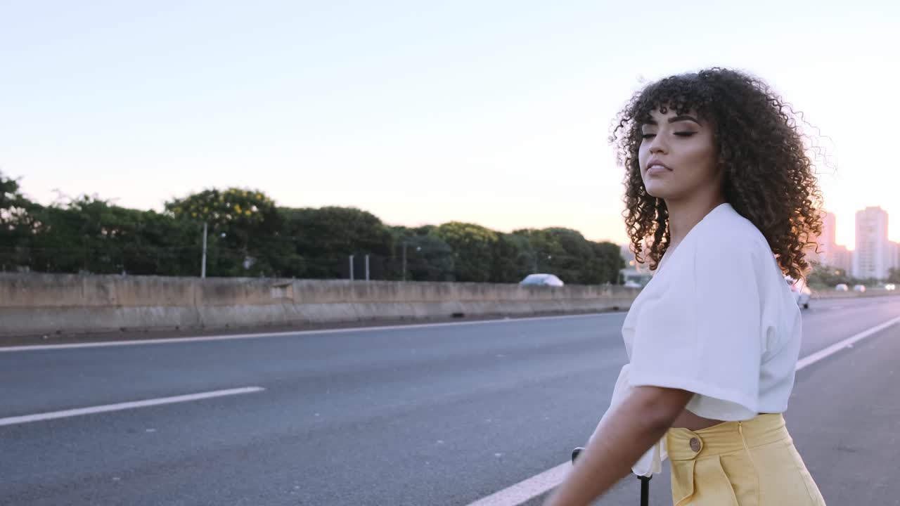 Donna con capelli ricci sull'autostrada