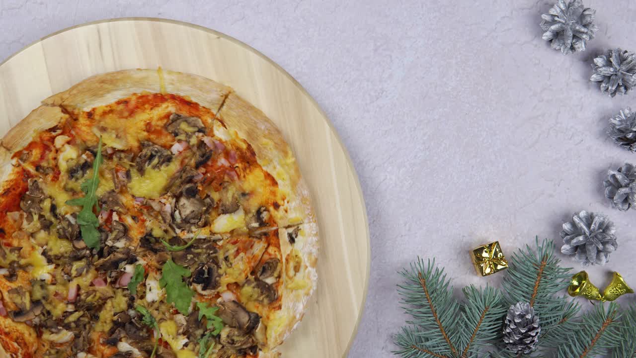 una capa plana de pizza girando una rotación de 360 grados en un salvador de madera, decoraciones navideñas alrededor