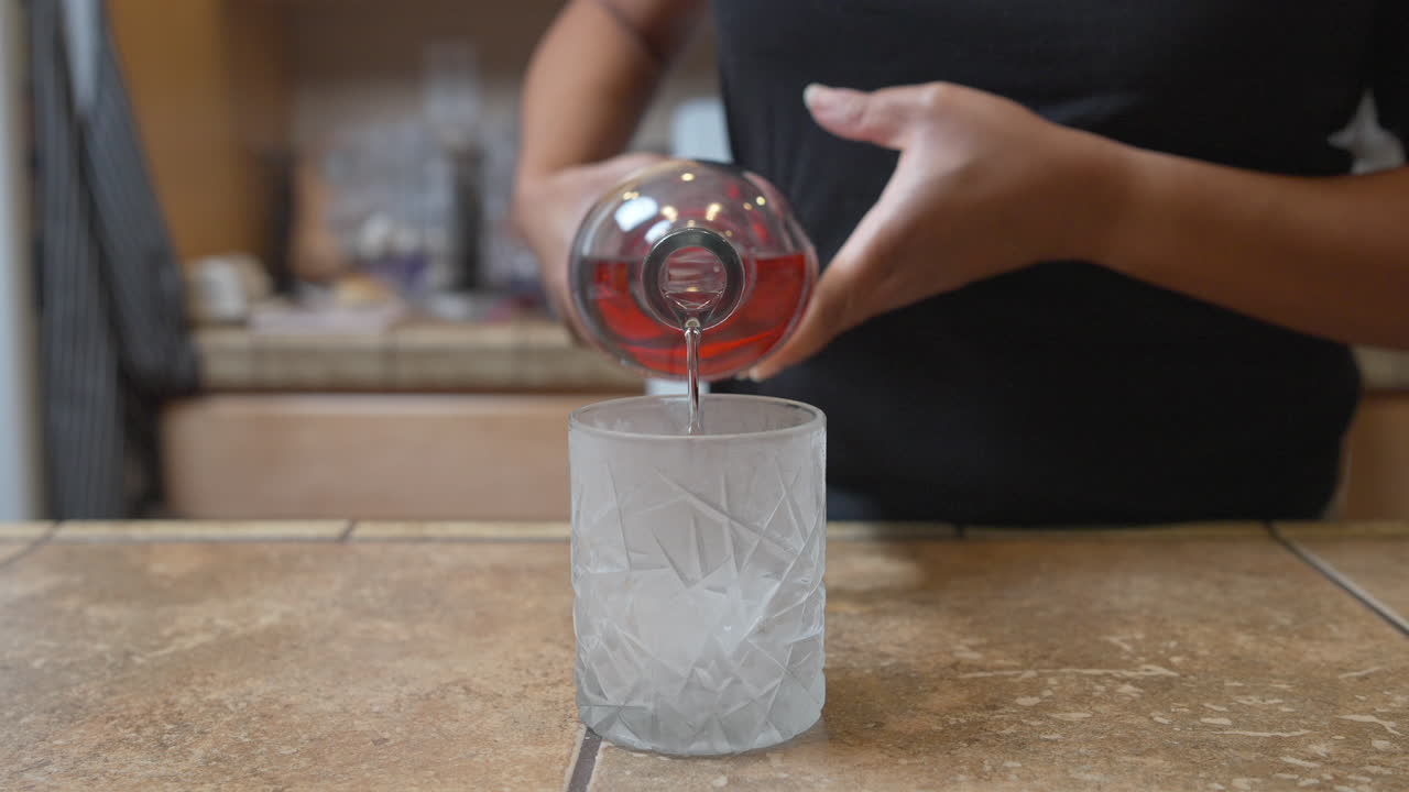 verter vodka en un vaso helado de hielo - cámara lenta