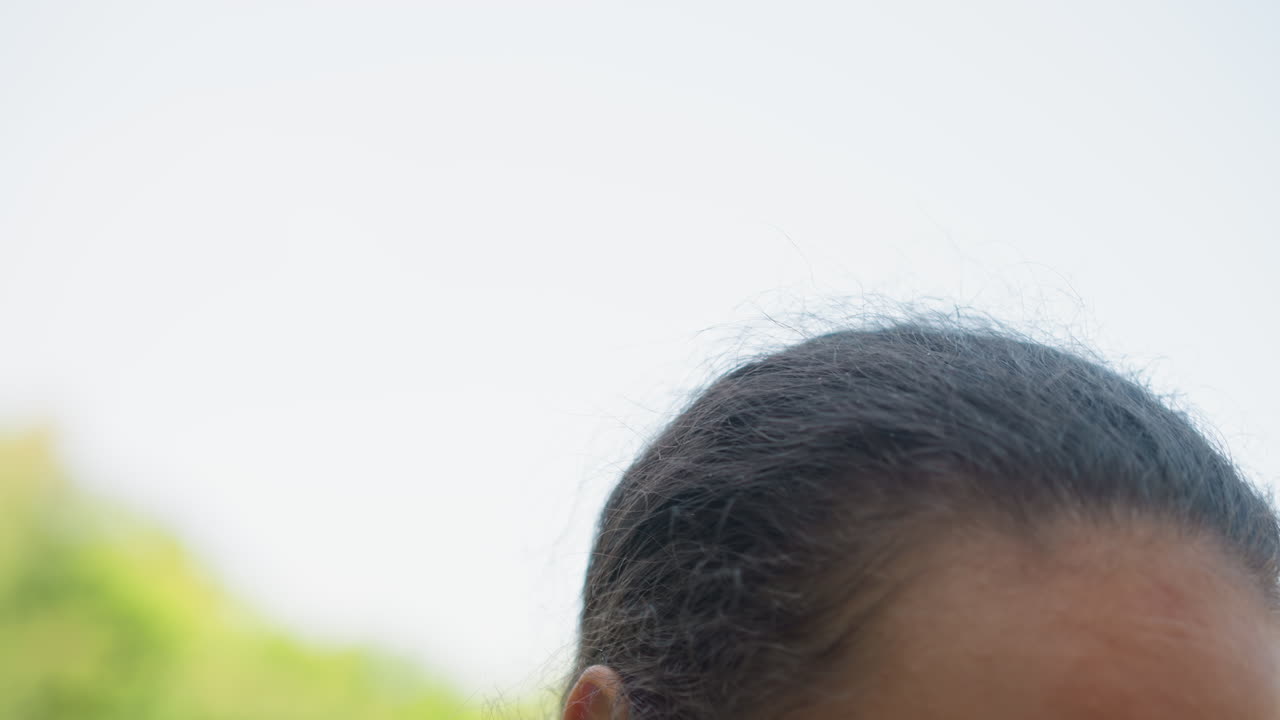 Female athlete fixing her cap before exercise, Young woman readies herself outdoors for running activity, Woman prepares herself outdoors by adjusting her cap before sprinting exercise outside