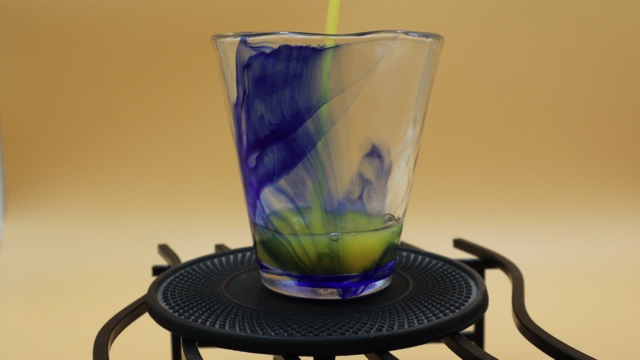 el jugo de naranja se vierte en un vaso sobre un fondo amarillo