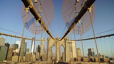 commuters crossing brooklyn bridge in new york on a sunny evening