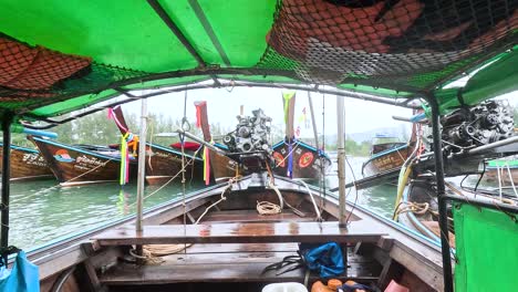 longtail boats in a tropical bay during rainy weather