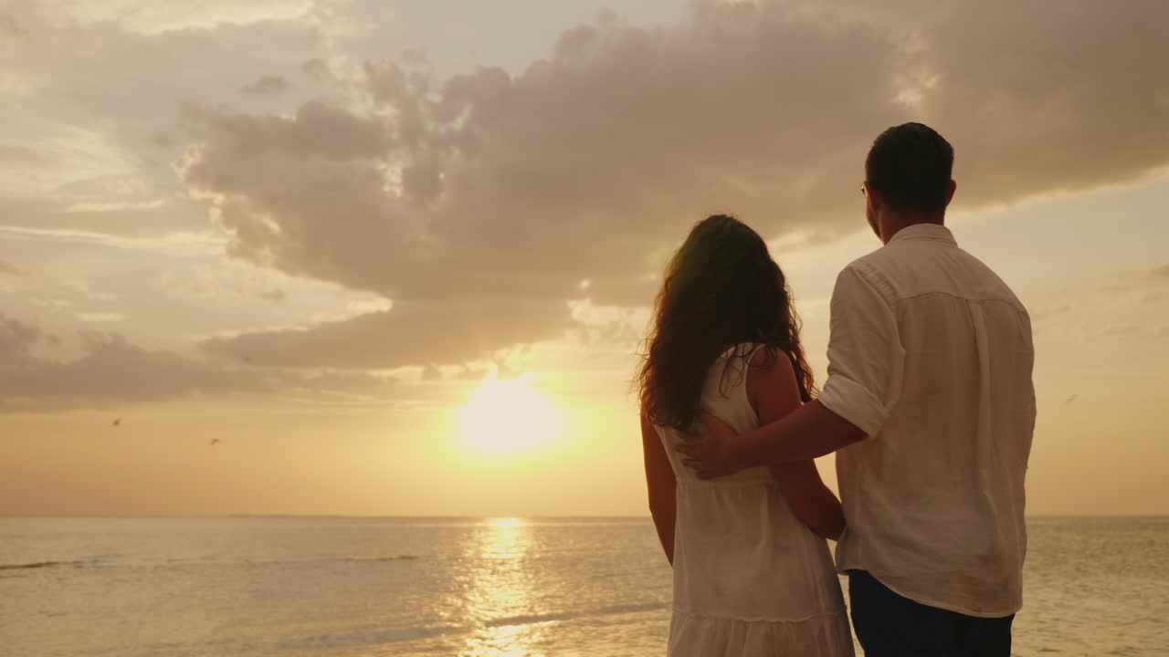 Young Couple In Love Embraces Look Together Forward To The Sunset By The  Sea Back View Hd Video Free Stock Video Footage Download Clips Water