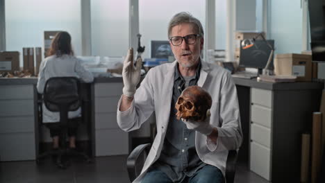científico que presenta el cráneo humano en el laboratorio