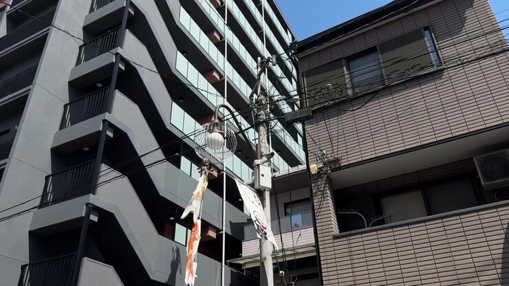 Cena de rua urbana no Japão, edifício de apartamentos cinzento de vários andares com escadas externas