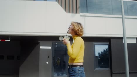 woman walking in city with a drink