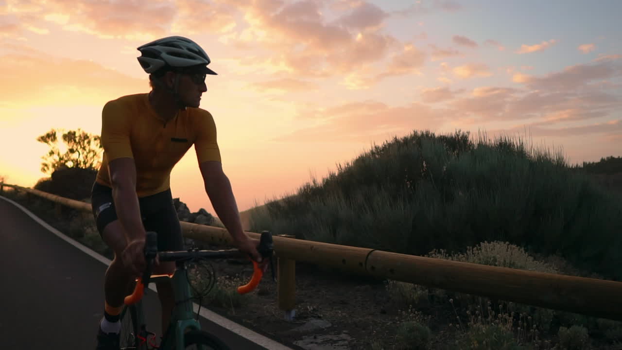 In slow motion, on a mountain serpentine, the athlete cyclist enjoys the island's view, embodying the principles of a healthy lifestyle