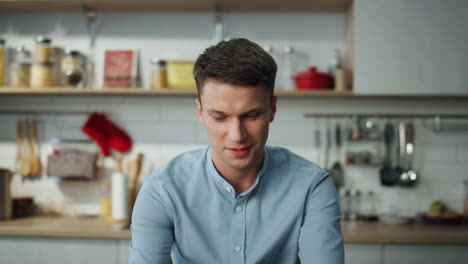 Man-communicating-online-laptop-sitting-at-kitchen-close-up.-Manager-working.