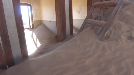 sand blows through an abandoned building in the gem mining ghost town of kolmanskop namibia 4