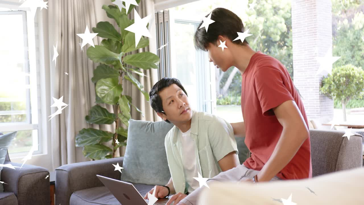 Teenager leaning pointing at laptop guiding father animated stars marking learning chatting on sofa