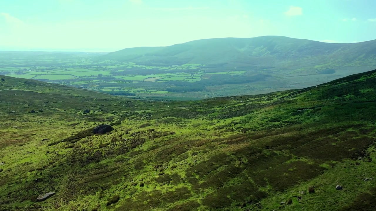 Veduta aerea di una cresta montuosa con sentiero, con vista sul lontano paesaggio verde nel Sud dell'Irlanda