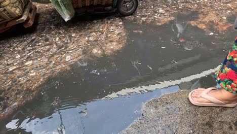 people walking around puddles in a busy market